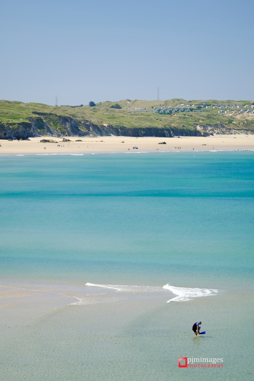 Man on Godrevy beach in the shallow water in Summer